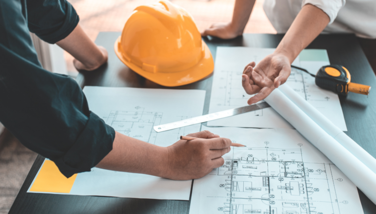 Construction project managers reviewing Davis-Bacon requirements and wage determinations before submitting a bid on a federally funded project