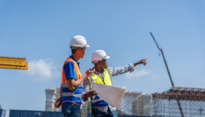 Construction project team reviewing plans on a public infrastructure job site during infrastructure compliance planning.