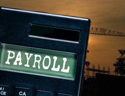 Construction team reviewing certified construction payroll documents on a job site to ensure prevailing wage compliance.