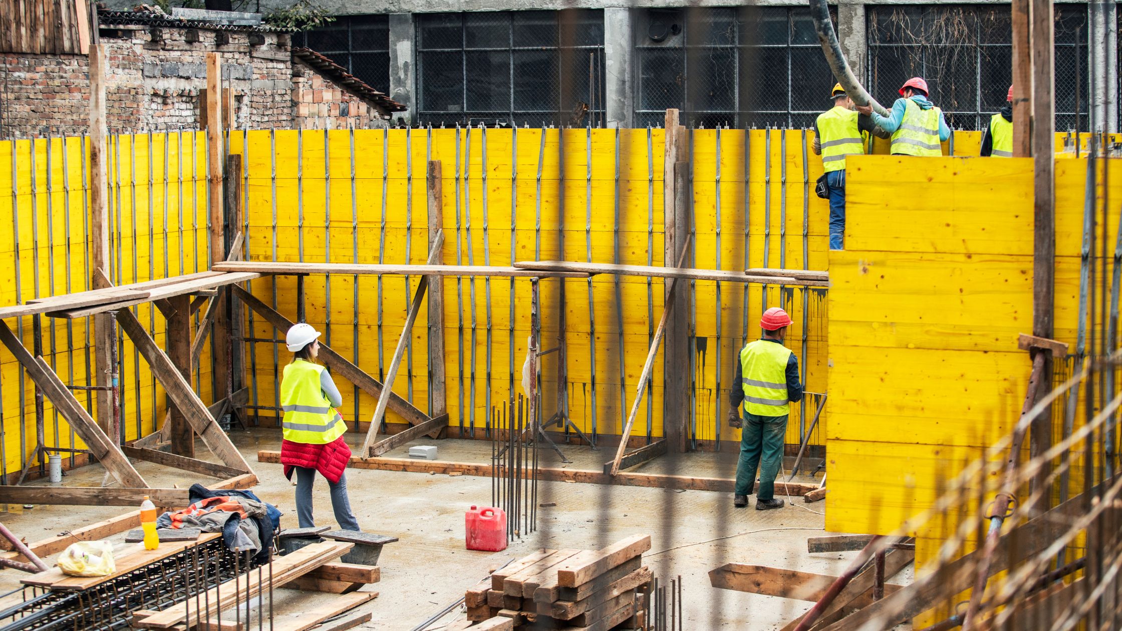 Construction contractor reviewing Davis-Bacon compliance documents and certified payroll forms on a job site.